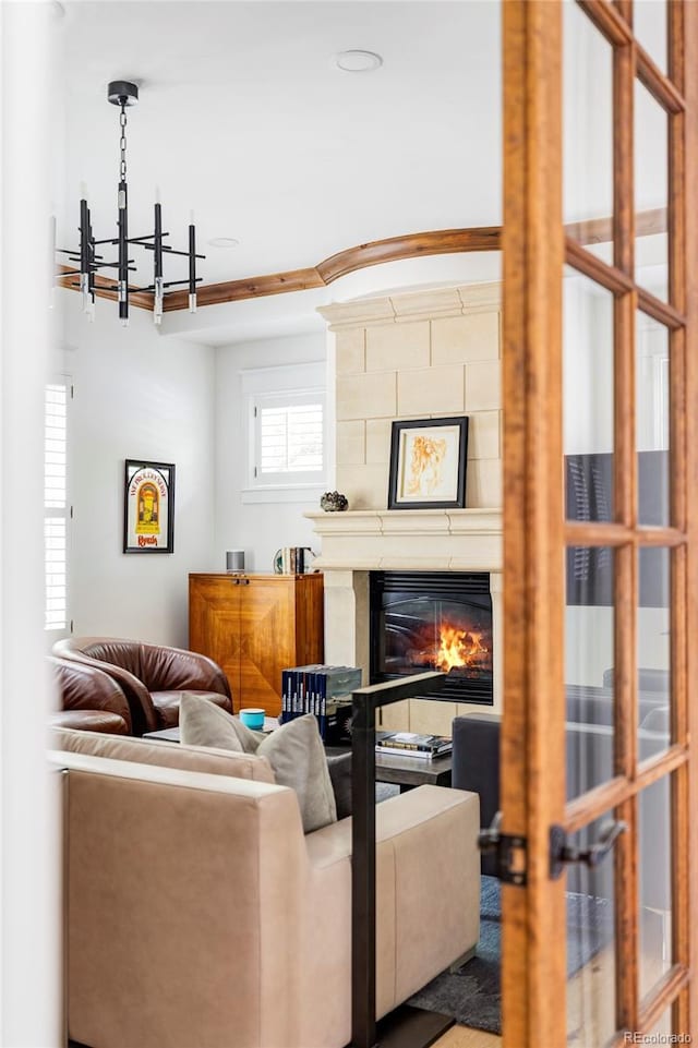 living room with a large fireplace and a notable chandelier