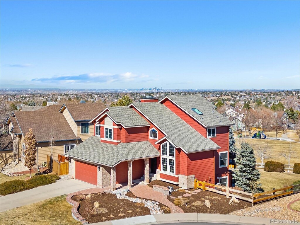 view of front of property featuring driveway, a shingled roof, an attached garage, and fence