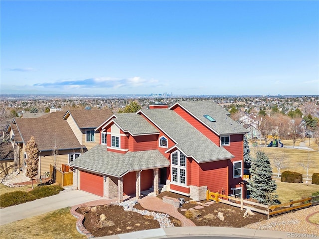 view of front of property featuring driveway, a shingled roof, an attached garage, and fence