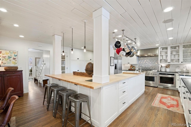 kitchen featuring high quality appliances, white cabinetry, wood ceiling, a kitchen island, and decorative backsplash