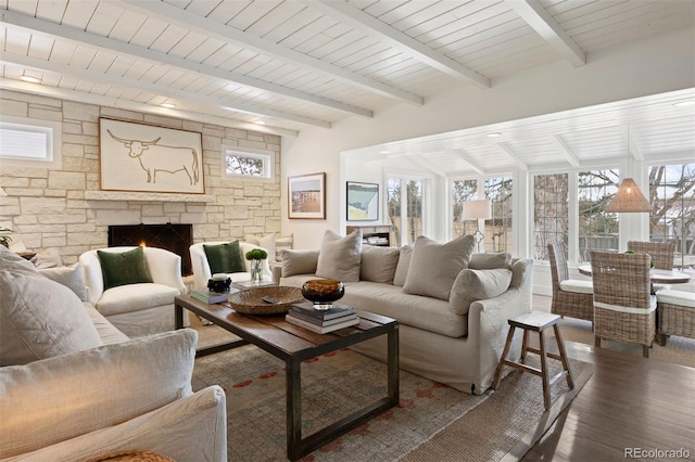 living room with a stone fireplace, beam ceiling, and dark hardwood / wood-style floors