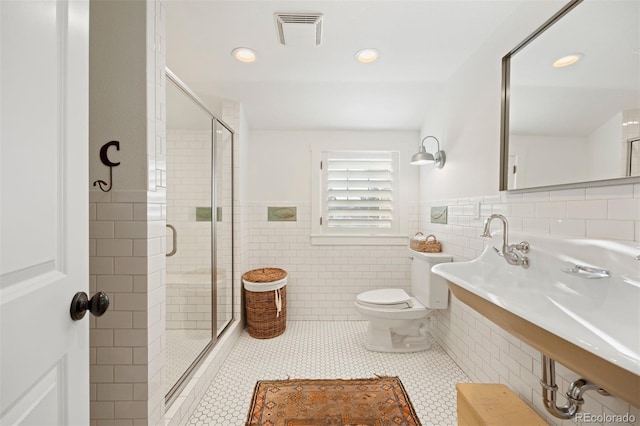 bathroom featuring tile walls, tile patterned floors, walk in shower, and toilet