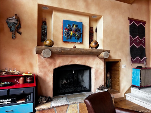 detailed view of wood finished floors and a fireplace with raised hearth