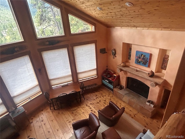 living room with healthy amount of natural light, wooden ceiling, light wood-style flooring, and lofted ceiling