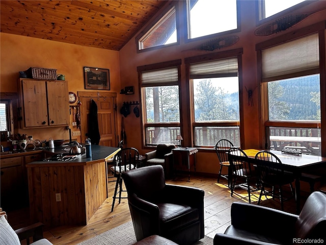 living room with light wood-style floors, plenty of natural light, high vaulted ceiling, and wood ceiling