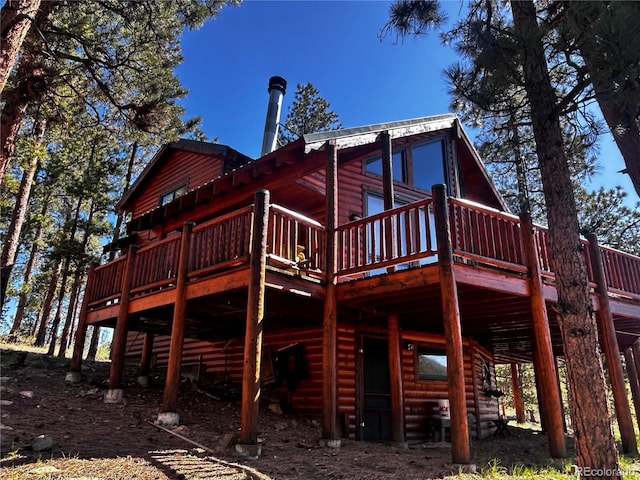 back of property featuring a wooden deck and log veneer siding