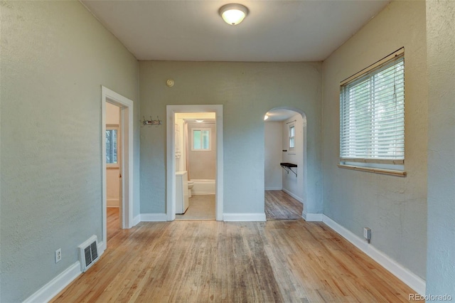 1707 W 39th Ave, Denver, CO 80211 - spare room featuring arched walkways, wood finished floors, and a textured wall