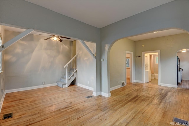 1707 W 39th Ave, Denver, CO 80211 - unfurnished room featuring arched walkways, a ceiling fan, wood finished floors, and stairs