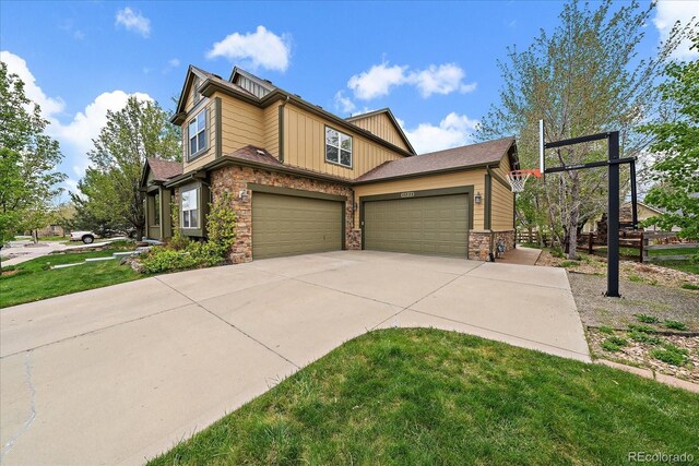 15258 W 75th Pl, Arvada, CO 80007 - view of side of property with stone siding, concrete driveway, board and batten siding, a yard, and a garage