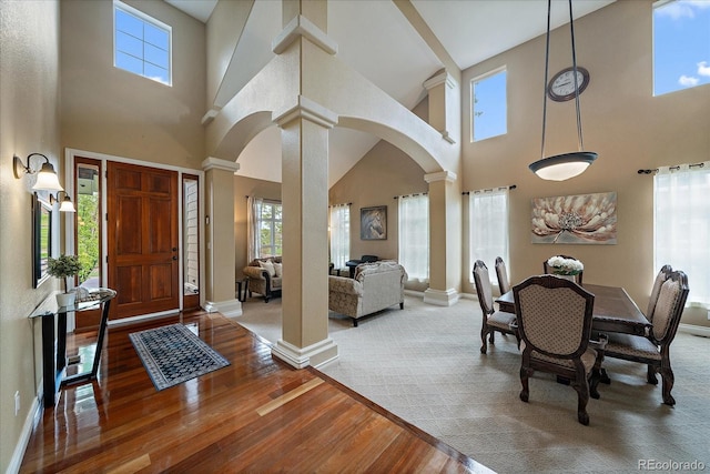 15258 W 75th Pl, Arvada, CO 80007 - entrance foyer with ornate columns, arched walkways, a towering ceiling, wood-type flooring, and baseboards