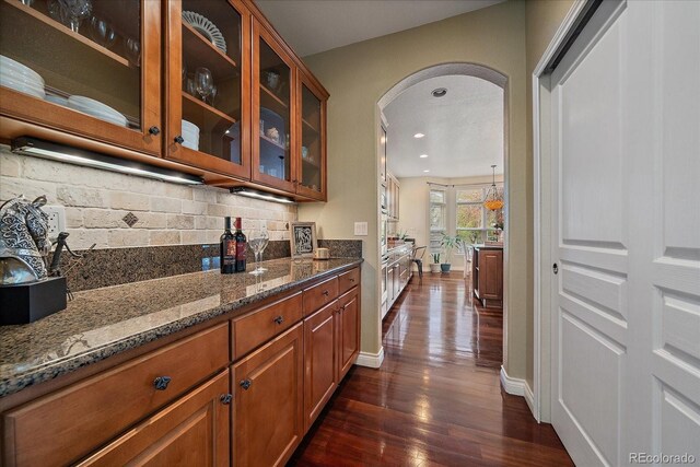 15258 W 75th Pl, Arvada, CO 80007 - bar with arched walkways, dark wood-type flooring, backsplash, baseboards, and recessed lighting
