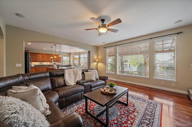 15258 W 75th Pl, Arvada, CO 80007 - living room with arched walkways, a ceiling fan, baseboards, wood finished floors, and recessed lighting