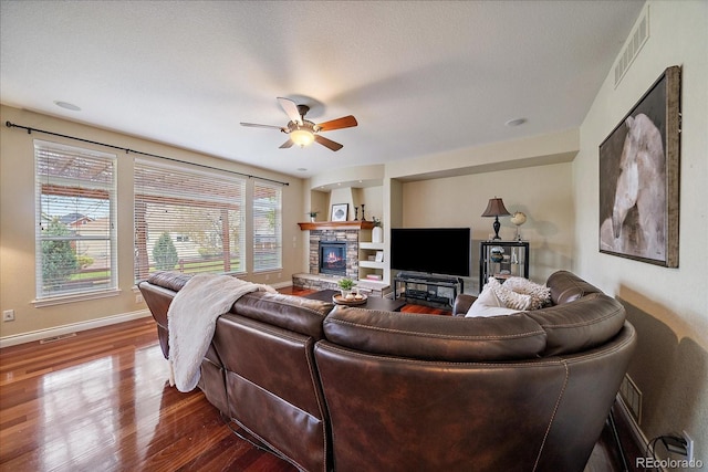 15258 W 75th Pl, Arvada, CO 80007 - living area with wood finished floors, a fireplace, a ceiling fan, and baseboards