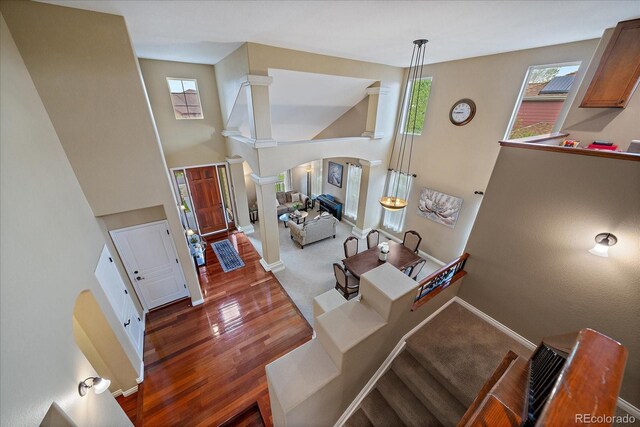 15258 W 75th Pl, Arvada, CO 80007 - entrance foyer featuring ornate columns, arched walkways, a high ceiling, baseboards, and wood finished floors