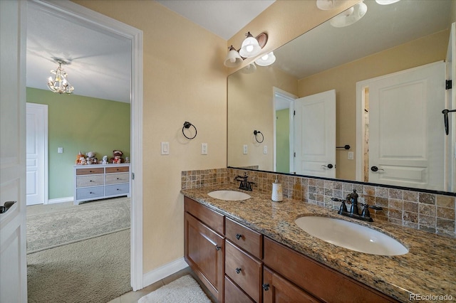 15258 W 75th Pl, Arvada, CO 80007 - bathroom featuring double vanity, baseboards, and a chandelier
