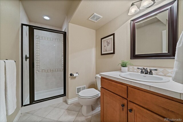 15258 W 75th Pl, Arvada, CO 80007 - bathroom featuring tile patterned flooring, toilet, vanity, a stall shower, and baseboards