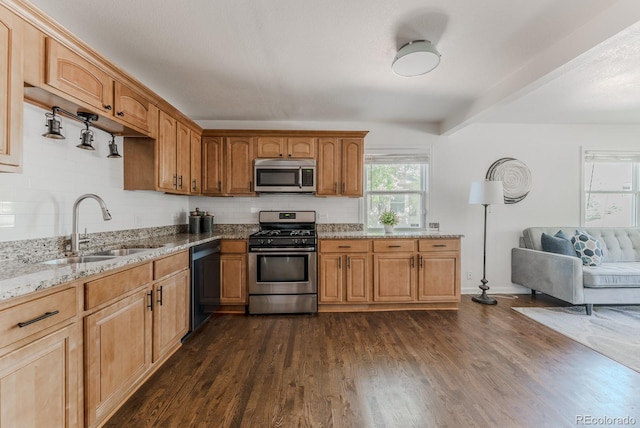 2260 Lilly Dr, Thornton, CO 80229 - kitchen featuring appliances with stainless steel finishes, light stone counters, dark wood-style flooring, backsplash, and brown cabinetry