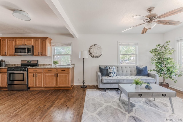 2260 Lilly Dr, Thornton, CO 80229 - living room with healthy amount of natural light, a ceiling fan, dark wood finished floors, and beamed ceiling