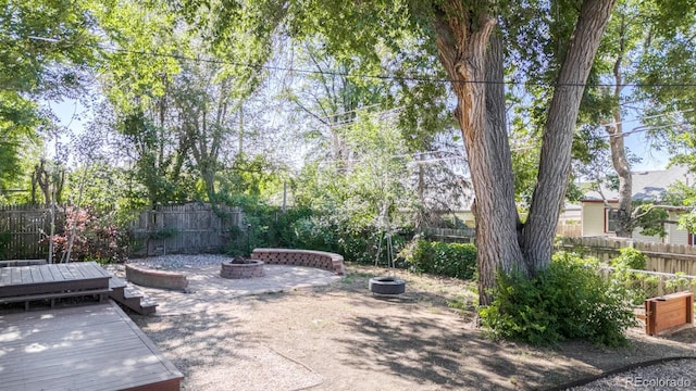 2260 Lilly Dr, Thornton, CO 80229 - fenced backyard with a fire pit and a deck