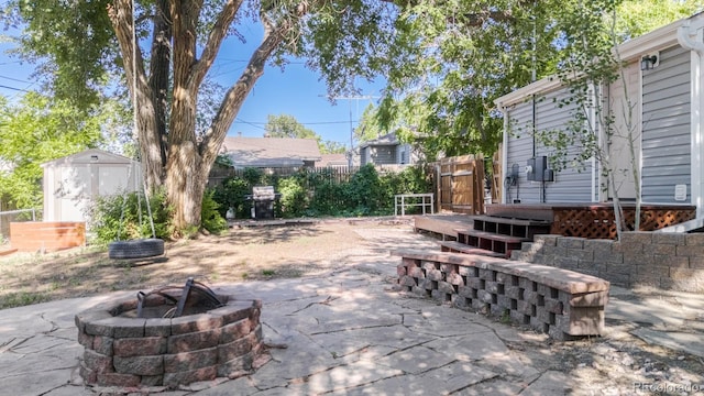 2260 Lilly Dr, Thornton, CO 80229 - fenced backyard with an outdoor fire pit, a storage shed, and a patio area