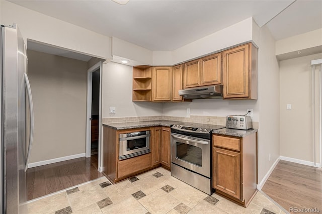 kitchen featuring under cabinet range hood, appliances with stainless steel finishes, and brown cabinetry