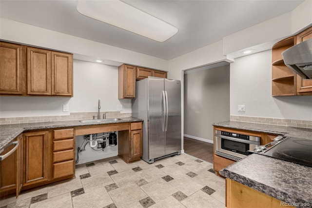 kitchen featuring open shelves, brown cabinetry, stainless steel appliances, and a sink