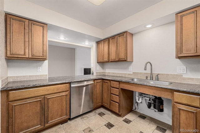 kitchen featuring brown cabinets, recessed lighting, a sink, dark stone countertops, and dishwasher