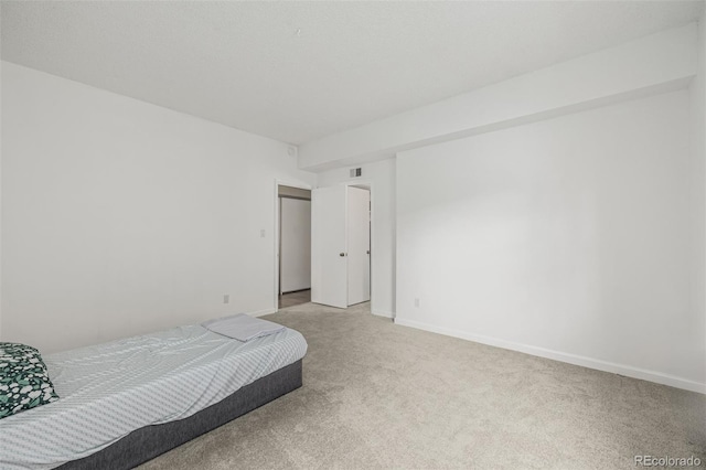 bedroom featuring visible vents, baseboards, and light colored carpet