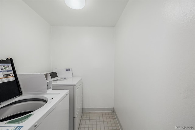 washroom featuring washer and clothes dryer and baseboards