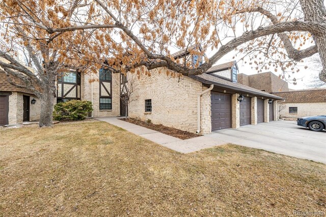 7250 Eastmoor Dr Unit 105, Denver, CO 80237 - view of home's exterior with driveway, a lawn, brick siding, and a garage