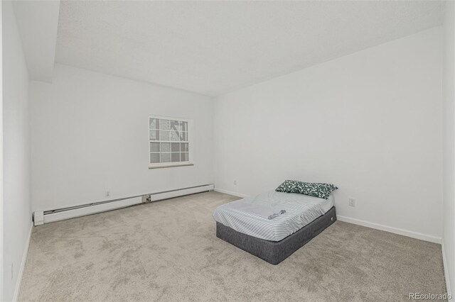 7250 Eastmoor Dr Unit 105, Denver, CO 80237 - bedroom with baseboard heating, carpet flooring, and baseboards