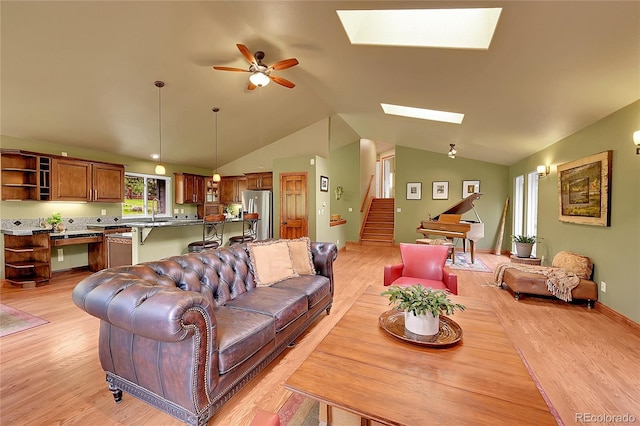 28065 Camel Heights Cir, Evergreen, CO 80439 - living room with a skylight, lofted ceiling, stairway, a ceiling fan, and light wood-type flooring