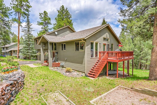 28065 Camel Heights Cir, Evergreen, CO 80439 - view of front of home featuring stairs, a deck, a front yard, a vegetable garden, and roof with shingles