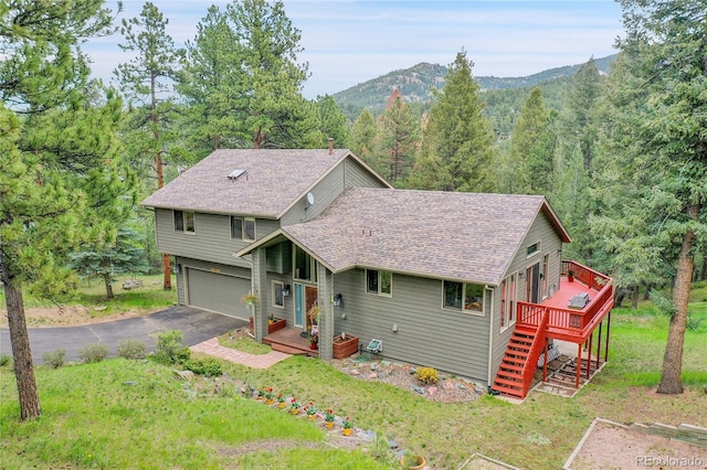 28065 Camel Heights Cir, Evergreen, CO 80439 - view of front of house featuring stairway, a deck with mountain view, an attached garage, asphalt driveway, and roof with shingles