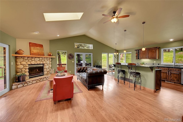 28065 Camel Heights Cir, Evergreen, CO 80439 - living area featuring ceiling fan, a fireplace, light wood-type flooring, healthy amount of natural light, and vaulted ceiling