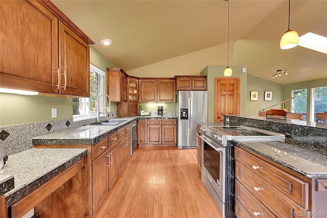 28065 Camel Heights Cir, Evergreen, CO 80439 - kitchen with appliances with stainless steel finishes, a sink, brown cabinetry, light wood-type flooring, and vaulted ceiling