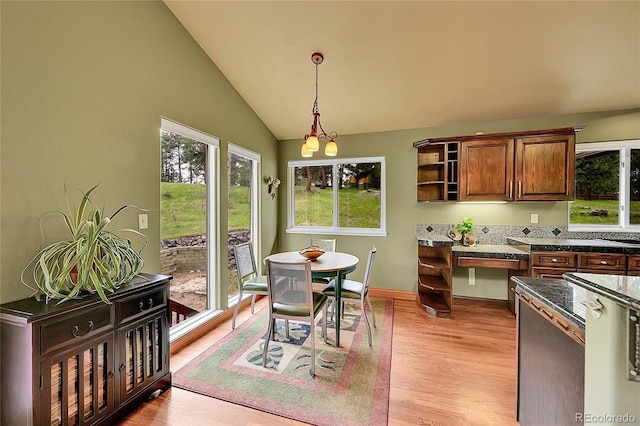 28065 Camel Heights Cir, Evergreen, CO 80439 - dining space featuring light wood-style floors, vaulted ceiling, and a chandelier