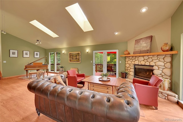 28065 Camel Heights Cir, Evergreen, CO 80439 - living room with lofted ceiling, a skylight, wood finished floors, a stone fireplace, and baseboards