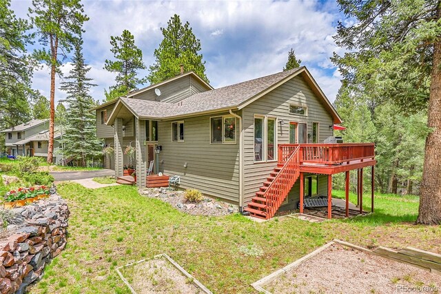 28065 Camel Heights Cir, Evergreen, CO 80439 - view of front of home featuring stairs, a deck, a front yard, a vegetable garden, and roof with shingles