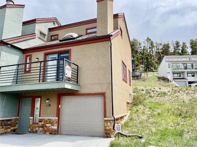 view of front of home featuring a garage and a balcony