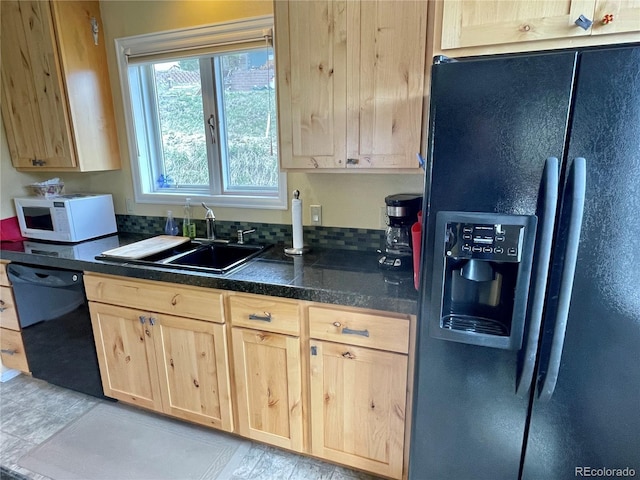 kitchen featuring light brown cabinetry, sink, and black appliances