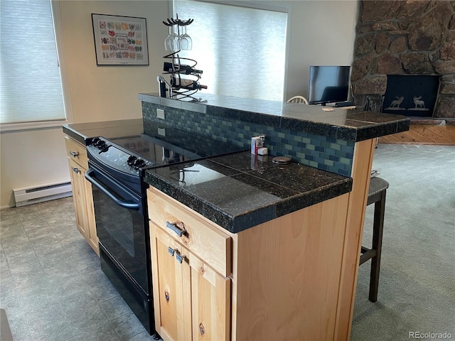 kitchen featuring a breakfast bar, light brown cabinets, baseboard heating, black range with electric stovetop, and decorative backsplash