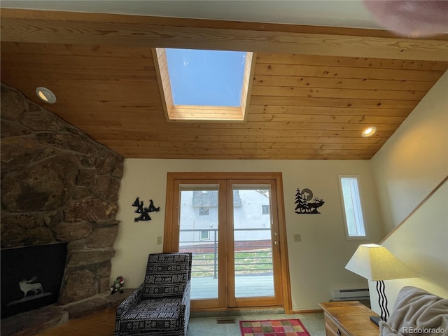 living room with a baseboard heating unit, wood ceiling, a fireplace, and lofted ceiling with skylight