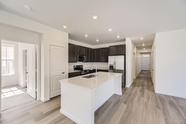 kitchen featuring a kitchen island with sink, stainless steel appliances, sink, and light hardwood / wood-style floors