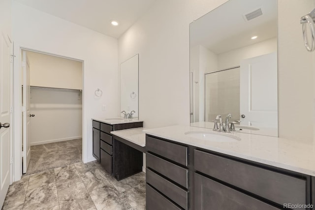 bathroom with a shower with door and vanity