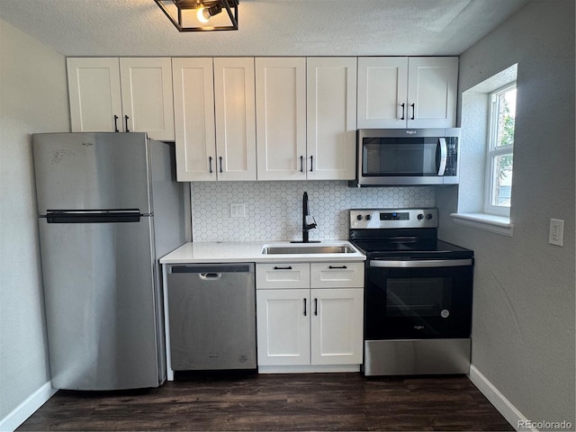 1285 Colorado Blvd Unit 3, Denver, CO 80206 - kitchen with stainless steel appliances, white cabinets, tasteful backsplash, dark wood-style floors, and a textured ceiling