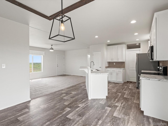 kitchen with white cabinetry, dark wood-type flooring, an island with sink, pendant lighting, and ceiling fan