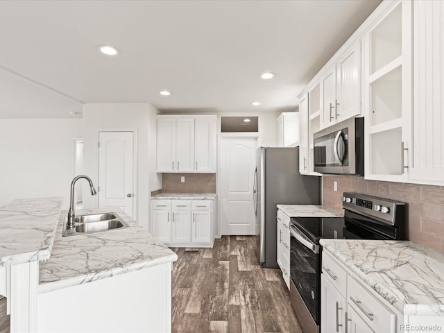 kitchen with tasteful backsplash, stainless steel appliances, dark wood-type flooring, sink, and white cabinets