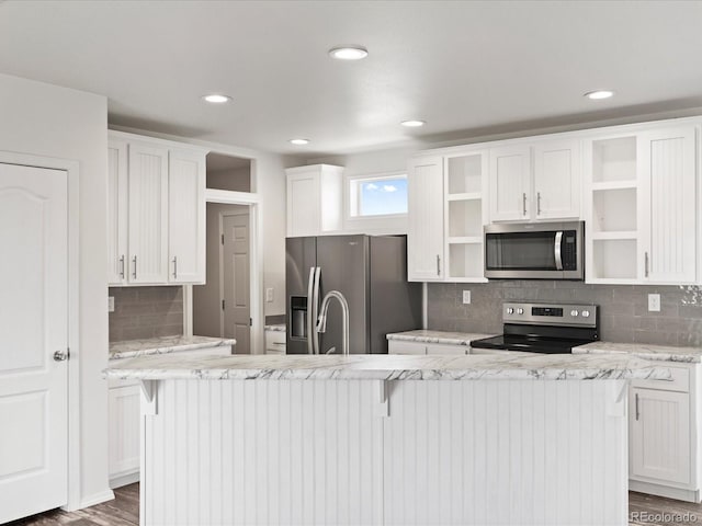 kitchen featuring dark hardwood / wood-style floors, stainless steel appliances, tasteful backsplash, and white cabinetry