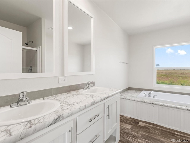 bathroom featuring dual bowl vanity, independent shower and bath, and wood-type flooring